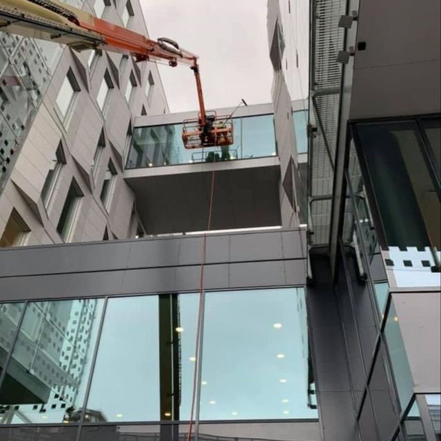 Vask av vinduer utenfor fasade, med lift